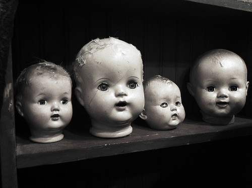 image of 4 doll heads on a shelf